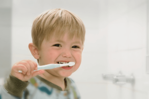 Young child brushing teeth with a toothbrush.