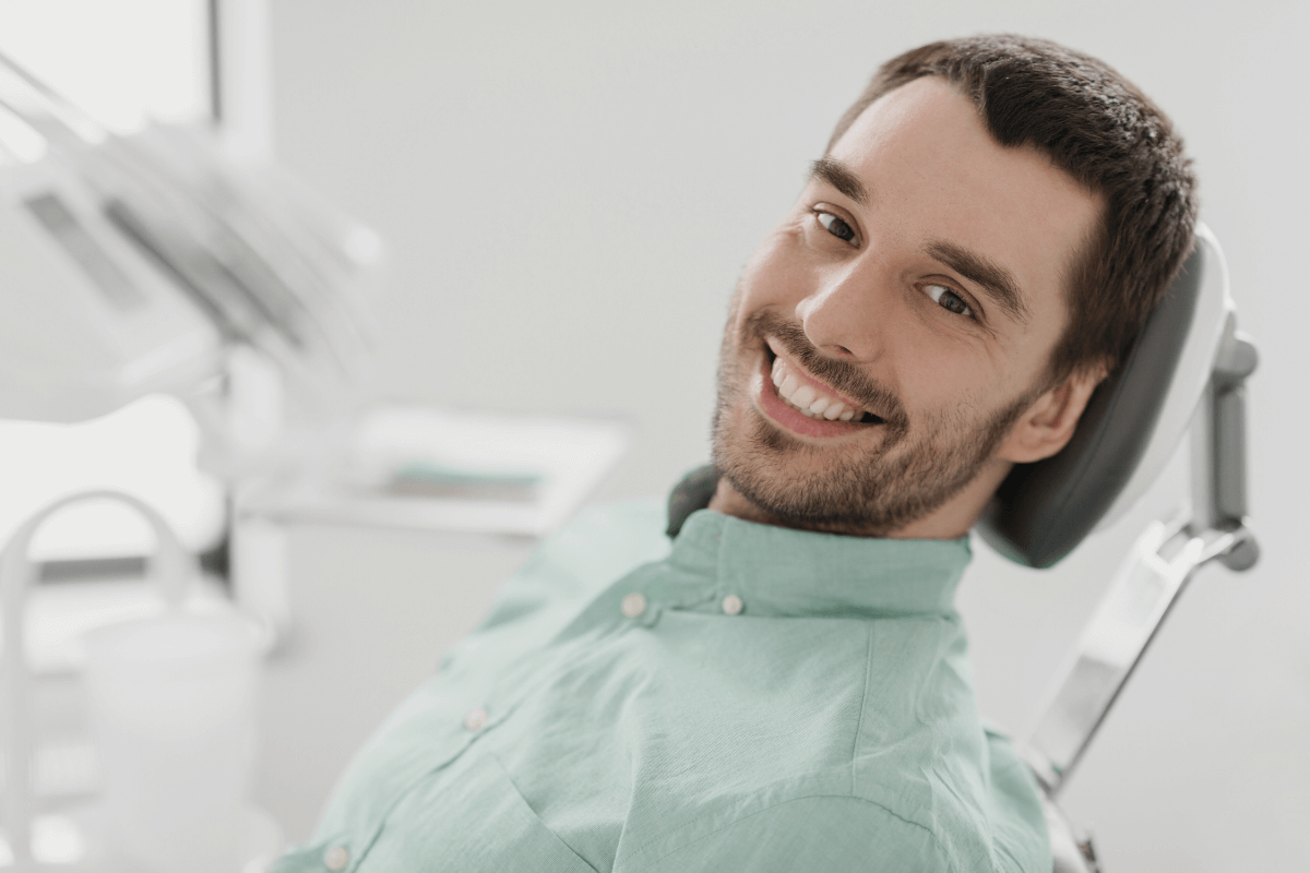 Happy male patient in a dental chair at Dentistry at City Center